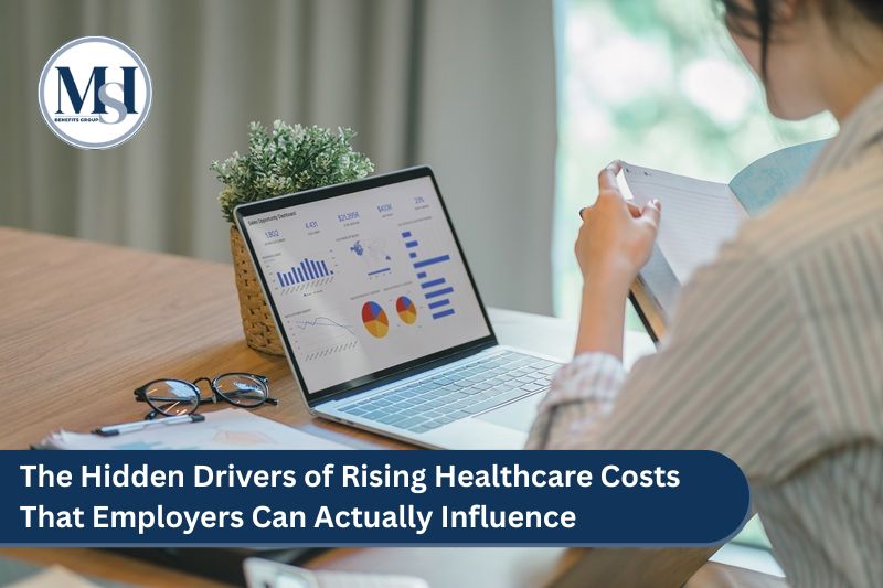 Employee benefits professional researching the Hidden Drivers of Rising Healthcare Costs That Employers Can Actually Influence on laptop.